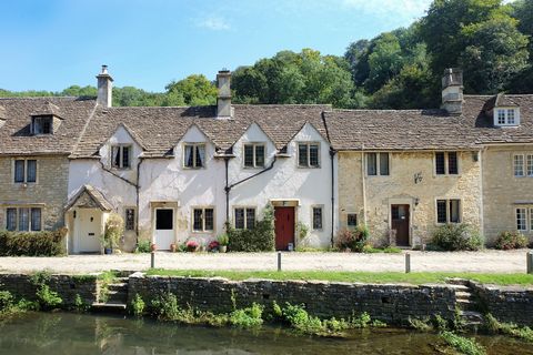 τα όμορφα σπίτια στο χωριό Bibury κάτω από το φως του ήλιου του καλοκαιριού στο Ηνωμένο Βασίλειο