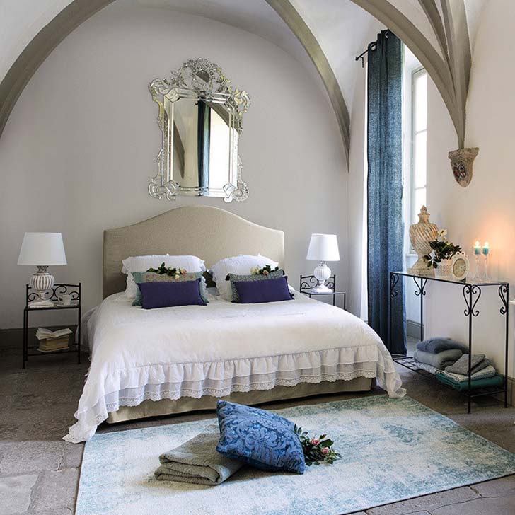 غرفة نوم بألوان الباستيل مع أرضية حجرية