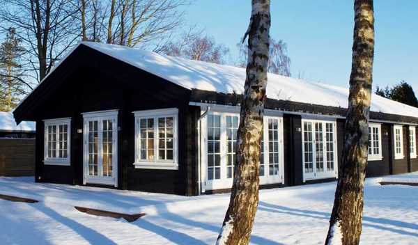 واجهة منزل أسود في الشتاء في الثلج