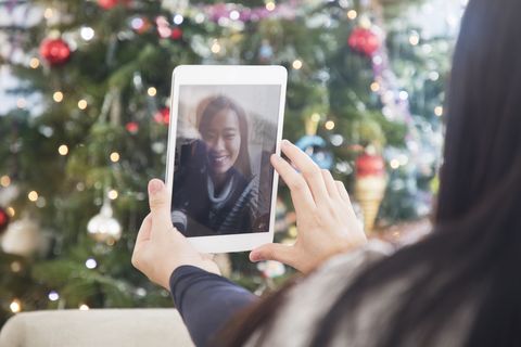 אישה משתמשת בטאבלט דיגיטלי לשיחת וידאו בחג המולד