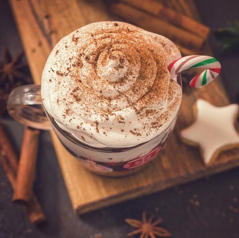 tasse de chocolat chaud avec crème fouettée et canne en bonbon dans une atmosphère chaleureuse de Noël