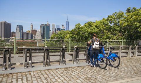 Femme prenant un vélo devant les toits de Manhattan à New York City