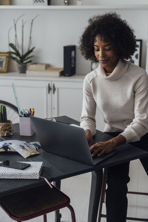 אישה עובדת במשרד הביתי שלה באמצעות מחשב נייד